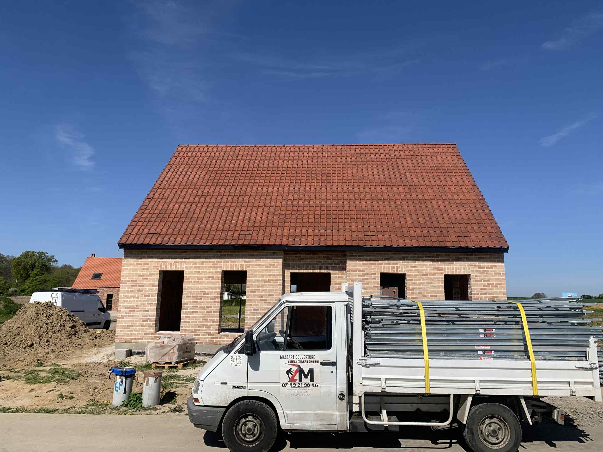 Construction d'une toiture en tuiles rouges sur une maison neuve à Lille par Massart Couverture