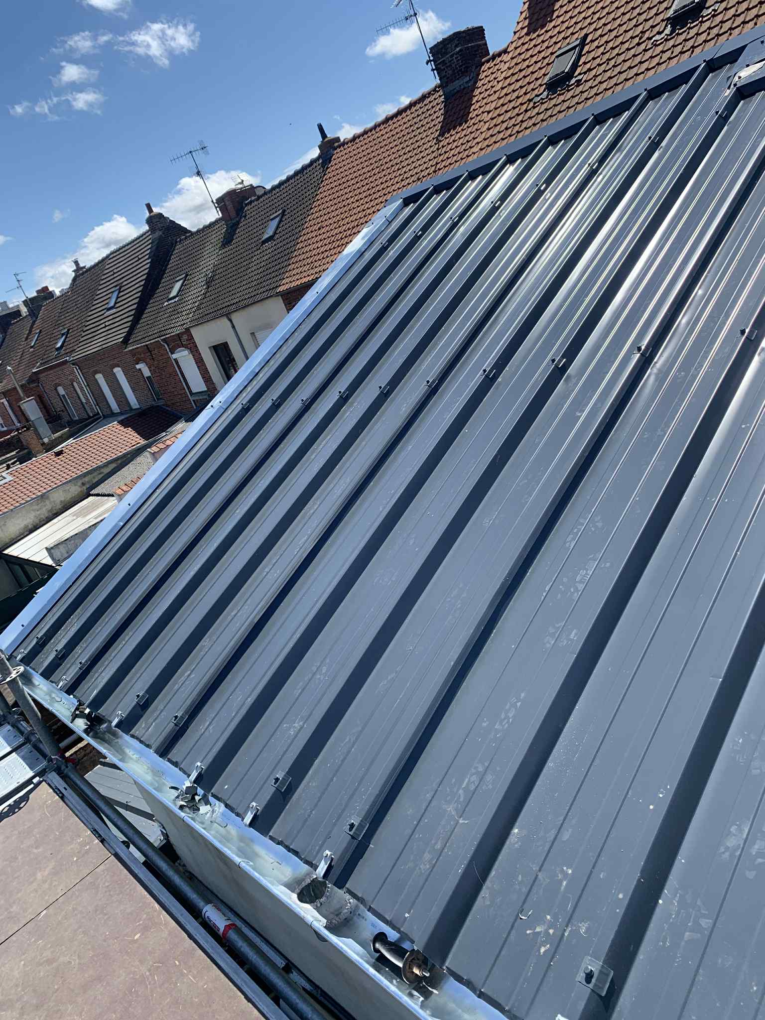 Pose d'une couverture en bac acier gris sur un toit en rénovation à Lille